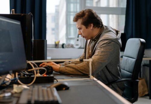 Free A concentrated professional working at a computer in a modern office setting. Stock Photo