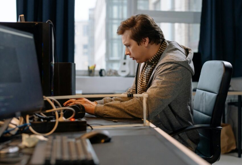 Free A concentrated professional working at a computer in a modern office setting. Stock Photo