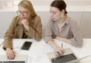 two women with laptops