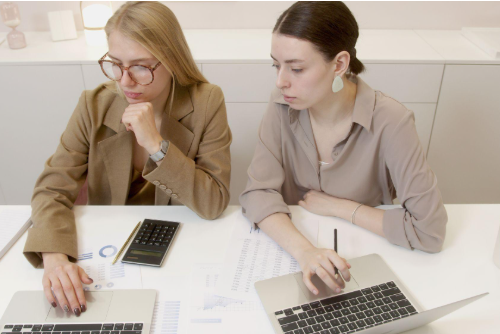 two women with laptops